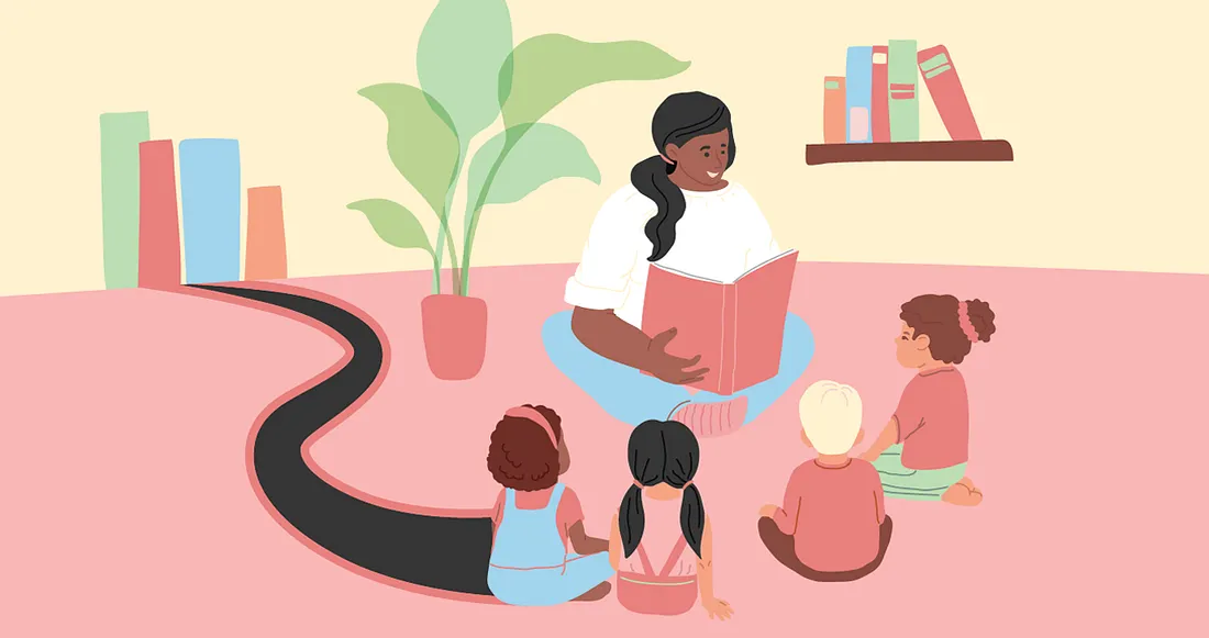 An adult is smiling and reading a book to a group of children who are sitting down.