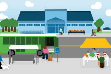 City street with a bus stop, farmers' market stall, and people walking, biking, and sitting near a large grocery store.